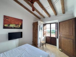 ファラニチュにあるFinca CanFirella Portocolomのベッドルーム(ベッド1台、テレビ、窓付)