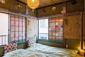 Schlafzimmer mit einem Bett und Buntglasfenstern in der Unterkunft I LOVE HANEDA in Tokio
