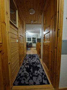 a hallway with wood paneled walls and a black rug at Levi -Sky Slope Apartment - 3 Bedrooms in Sirkka