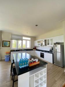 a kitchen with white cabinets and a black counter top at Sealink Beach Villa PE48- PE69 in Ấp Bình Hưng