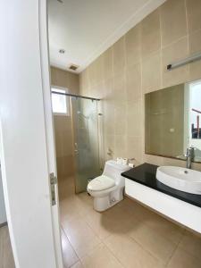 y baño con aseo, lavabo y ducha. en Sealink Beach Villa PE48- PE69 en Ấp Bình Hưng