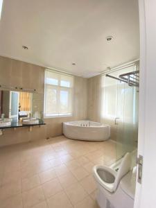 a bathroom with a tub and a toilet and a sink at Sealink Beach Villa PE48- PE69 in Ấp Bình Hưng