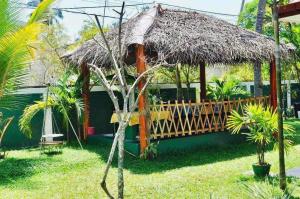 a house with a thatch roof and a porch at Aura Beach Villa in Awariwatta