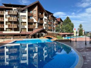 a large swimming pool in front of a hotel at Belvedere Holiday Club nice place in Bansko