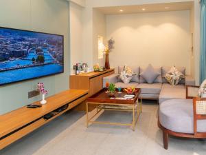 een woonkamer met een bank en een tv bij Calangute Towers - AM Hotel Kollection in Calangute