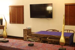a living room with a table and a flat screen tv at Shanti Boutique Hotel in Srithanu