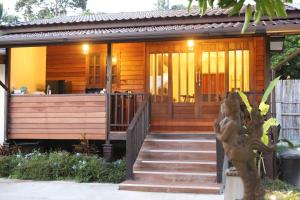 a wooden house with a staircase in front of it at Shanti Boutique Hotel in Srithanu