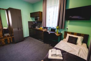 a bedroom with a bed and a desk with a laptop at Hotel Adela in Mielec