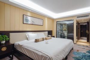 ein Schlafzimmer mit einem großen weißen Bett in einem Zimmer in der Unterkunft Guangdong Hotel in Guangzhou