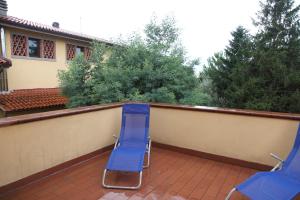 zwei blaue Gartenstühle auf einem Balkon in der Unterkunft Tiberio in Loro Ciuffenna