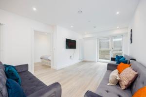 a living room with a couch and a television at 2&3 Bedrooms near EXCEL London - Modern Spacious Apartment For Larger Groups in London