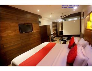 a bedroom with a bed and a flat screen tv at Hotel Relax Inn, Surat, Gujarat in Surat