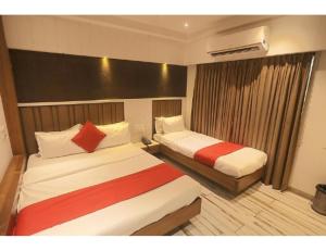 una camera d'albergo con due letti e una finestra di Hotel Relax Inn, Surat, Gujarat a Surat