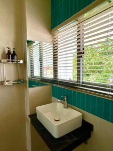 łazienka z białą umywalką i oknem w obiekcie Dk House Hue w mieście Hue