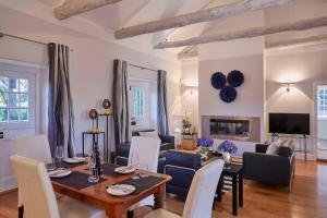 a dining room and living room with a table and chairs at Allèe Bleue Wine Estate in Simondium