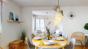 een eetkamer met een houten tafel en stoelen bij Elegance, appartement 6 pers 1 parking in Colmar
