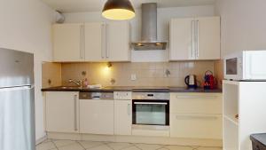 een keuken met witte kasten en een oven bij Elegance, appartement 6 pers 1 parking in Colmar