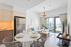 een keuken en een woonkamer met een tafel en stoelen bij Nasma Luxury Stays - Burj Royale 2BR Apartment in Downtown With Views in Dubai
