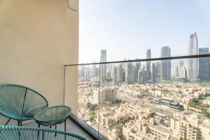a balcony with two chairs and a view of a city at Nasma Luxury Stays - Burj Royale 2BR Apartment in Downtown With Views in Dubai