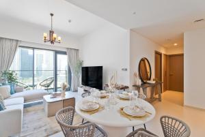 een woonkamer met een witte tafel en stoelen bij Nasma Luxury Stays - Burj Royale 2BR Apartment in Downtown With Views in Dubai