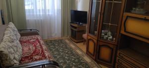 a hotel room with a couch and a television at Санаторій Збруч in Satanov