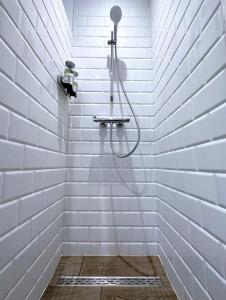 a shower in a white tiled bathroom with at Hypercentre Appart 2 à4 pers Calme & Cosy avec Terrasse Privée in Nantes