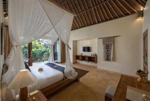 a bedroom with a bed and a balcony at The Sankara Resort by Pramana in Ubud