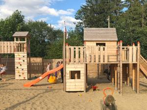 a childrens playground with a wooden play structure at Ranchhouse Bubble - Westernstable - Horse in Elterlein