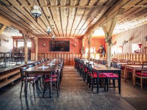 un restaurante con paredes de madera, mesas y sillas en Ranchhouse Bubble - Westernstable - Horse, en Elterlein