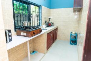 a kitchen with a counter with a stove and a window at Vyemma Residence in Limbe