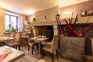 a dining room with a table and a fireplace at Hostellerie Maleville, logis hôtel Pontet in Beynac-et-Cazenac
