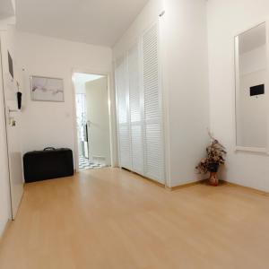 ein leeres Zimmer mit weißen Wänden und Holzboden in der Unterkunft Good located Apartment Subway U6 Wohnung in Berlin