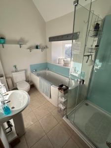 a bathroom with a tub and a toilet and a sink at Turnpike Cottage in Tetbury