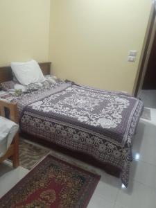 a bedroom with a bed and two rugs on the floor at Kazpilkna Beach Neighborhoods in Hurghada