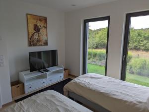 a bedroom with two beds and a flat screen tv at High-End Modern 2 Bed w. Garage in Belair in Luxembourg