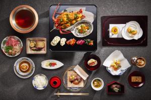 a table with plates of food and cups of tea at Waqoo Naritasanmonzen 和空 成田山門前 in Narita