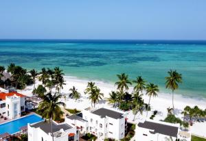 - une vue aérienne sur une plage bordée de palmiers et de bâtiments dans l'établissement LUX Marijani Zanzibar, à Pwani Mchangani