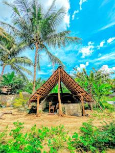 a small hut with a palm tree in the background at Maika safari lodge in Udawalawe