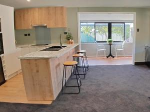 a kitchen with a counter and stools in a room at Holiday retreat in the heart of old Cromwell! in Cromwell