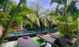 a swimming pool with palm trees and lounge chairs at Central Corner d'Angkor in Siem Reap