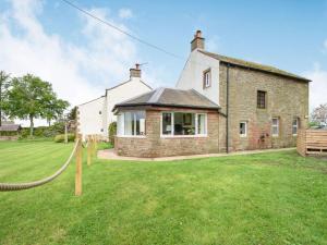 a large brick house with a grass yard at 3 bed in Caldbeck 88035 