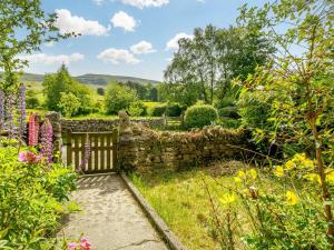 a garden with a gate and a stone wall at 3 Bed in Kirkby Stephen 88517 in Outhgill