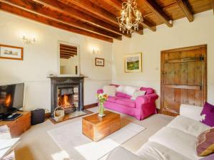 a living room with a pink couch and a fireplace at 3 Bed in Kirkby Stephen 88517 in Outhgill