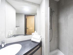 a bathroom with a sink and a shower at B&B Hotel Dessau in Dessau