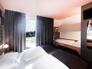 a hotel room with two beds and a window at B&B Hotel Dessau in Dessau