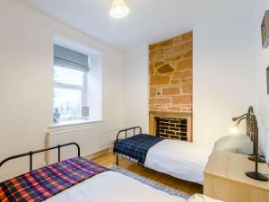 a bedroom with two beds and a fireplace at 3 Bed in Lockerbie 89406 in Lockerbie