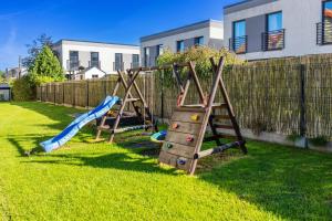 a playground with two swings in a yard at Willa Chantal in Jastrzębia Góra