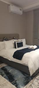 a bedroom with a large bed with white sheets and pillows at Menlyn Maine Trilogy Penthouse 42 in Pretoria