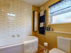 a bathroom with a tub and a toilet and a window at 1 Bed in Freshwater 89576 in Freshwater