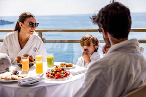 a group of people sitting at a table with food at Fairmont Monte Carlo in Monte Carlo